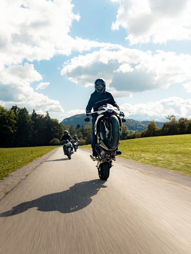 Moto Fahrer macht Wheelie auf Landstrasse