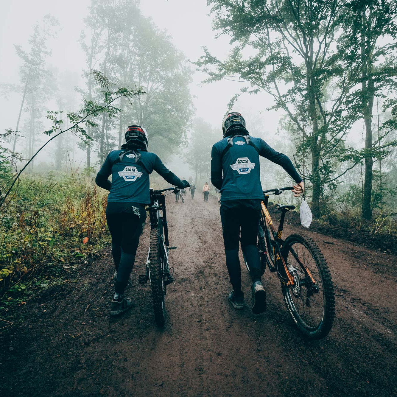 2 MTB Fahrer stossen ihre Bikes - Nebel